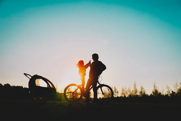 快乐的父亲和小女儿在日落骑自行车 — 图库照片