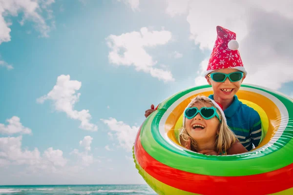 Happy Kids-jongen en meisje-vieren van Kerstmis op tropisch strand — Stockfoto