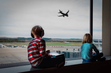 havaalanında bekleyen cep telefonu ve dokunmatik yüzey ile erkek ve kız