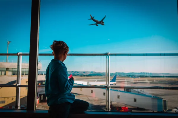 Fiú vár repülőtéren nézett repülőgépek, családi utazás — Stock Fotó