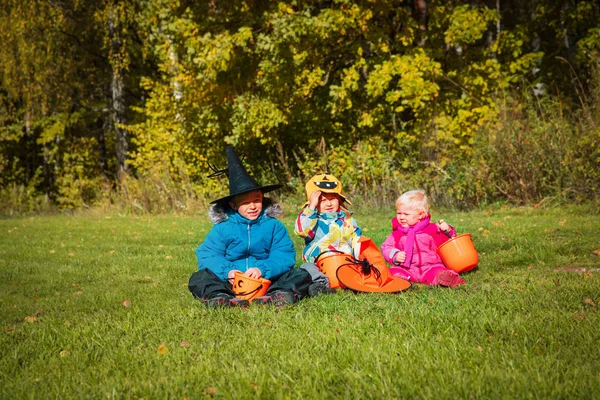 Niños en halloween juego de disfraces en la naturaleza, truco o tratamiento —  Fotos de Stock