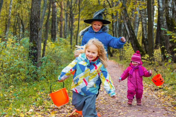 kids celebrating halloween, boy and girls trick or treating in autumn