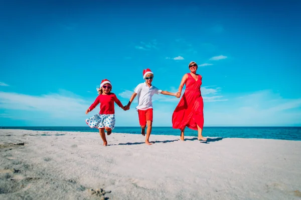 Šťastná rodina-Matka, syn a dcera-slavit Vánoce na pláži — Stock fotografie