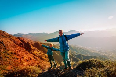 Mutlu baba ve oğul gün batımı dağlarda yürüyüş
