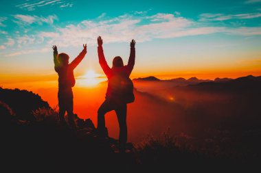 mutlu anne ve oğlu dağda günbatımında seyahat