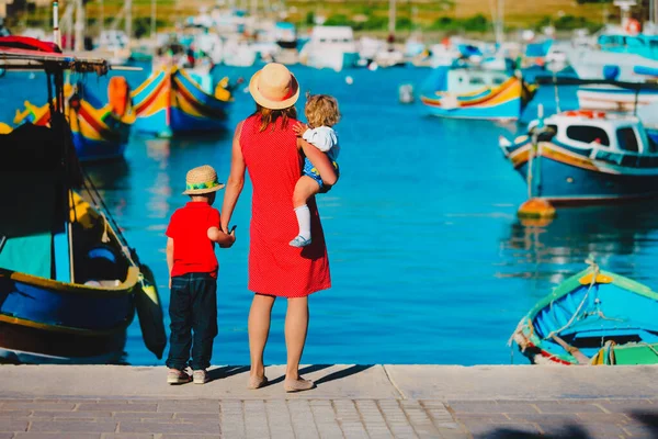 Mother and kids looking at traditional boats in Malta — Stock Photo, Image