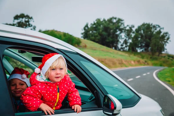 Boże Narodzenie samochód podróży- szczęśliwydziewczyna i chłopiec podróży w zimie — Zdjęcie stockowe