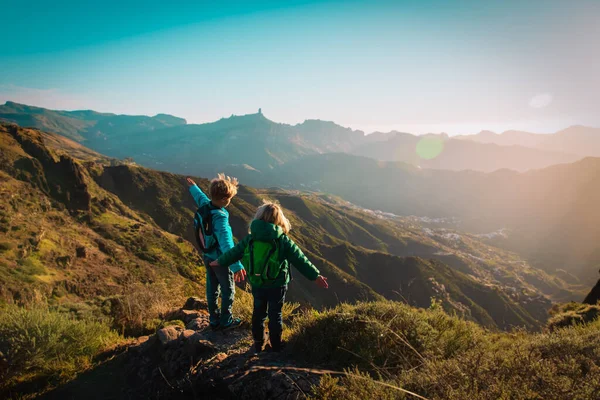 幸せな少年と女の子は日没時に山で旅行 — ストック写真