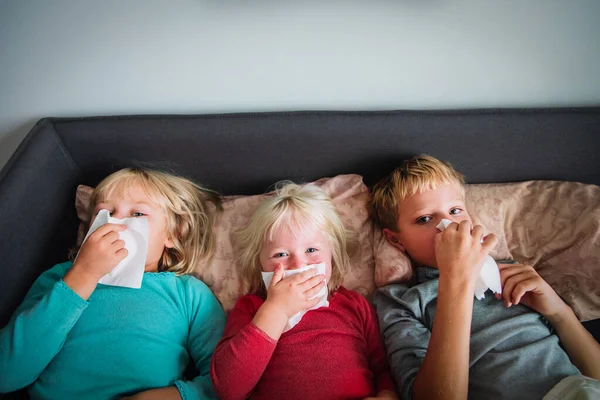 Діти витирають і дують ніс в ліжку, інфекції або алергії — стокове фото