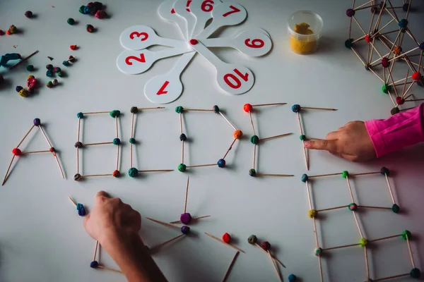 Niños haciendo letras y formas geométricas a partir de arcilla y palos, ingeniería y STEM — Foto de Stock