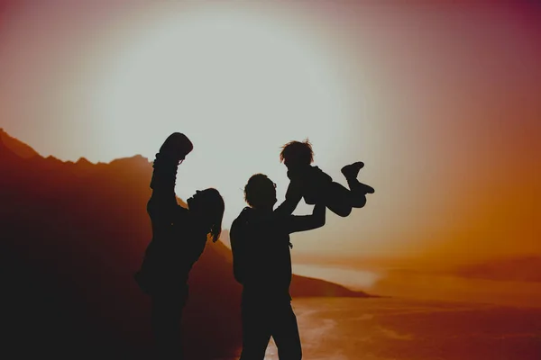 Família feliz mãe, pai e duas crianças viajam nas montanhas ao pôr do sol — Fotografia de Stock