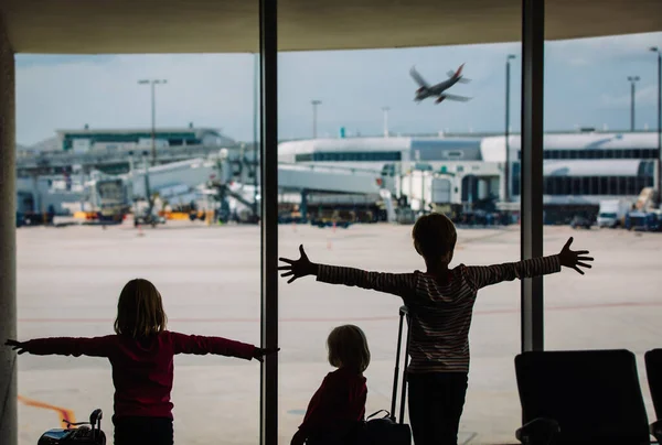 Niños felices esperando un avión en el aeropuerto — Foto de Stock