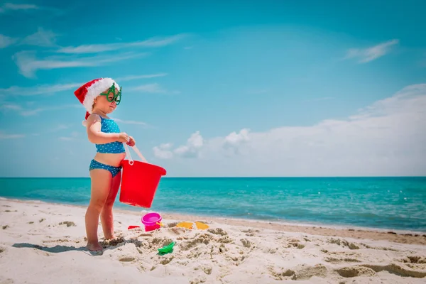 Süßes kleines Mädchen feiert Weihnachten am tropischen Strand — Stockfoto