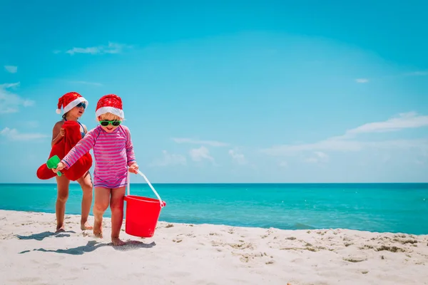Słodkie małe dziewczynki świętując Boże Narodzenie na tropikalnej plaży — Zdjęcie stockowe