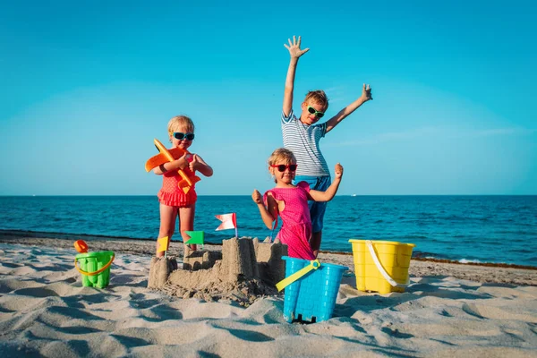 Crianças felizes - menino e meninas - brincar com areia na praia — Fotografia de Stock