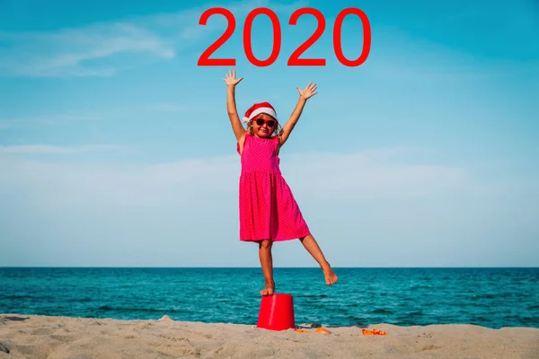 Mutlu küçük kız yeni yılı ve 2020 yılını sahilde kutluyor. — Stok fotoğraf