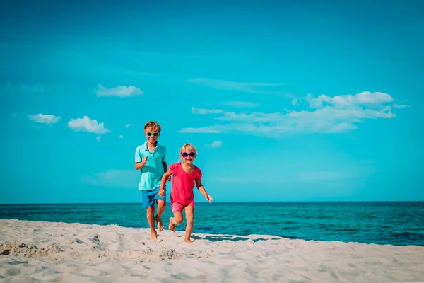 Mały chłopiec i dziewczynka uruchomiona na plaży — Zdjęcie stockowe