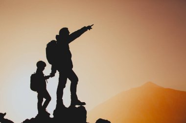 Baba ve oğul gün batımı dağlarında seyahat ederler.