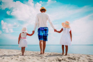 iki kızı ile baba sahilde yürüyüş