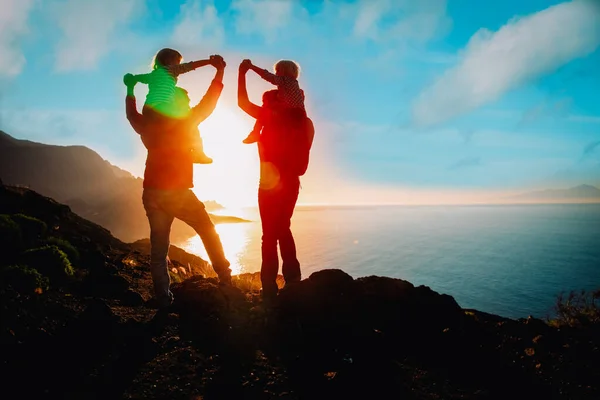 Família feliz com crianças viajar em montanhas ao pôr do sol — Fotografia de Stock