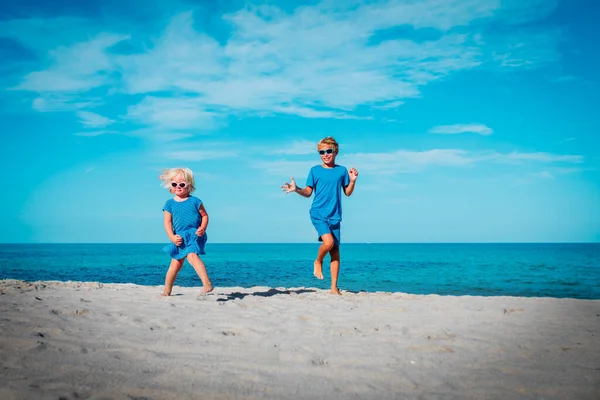 Güzel kız ve erkek sahilde dans ediyor, çocuklar tropikal tatilin tadını çıkarıyor. — Stok fotoğraf