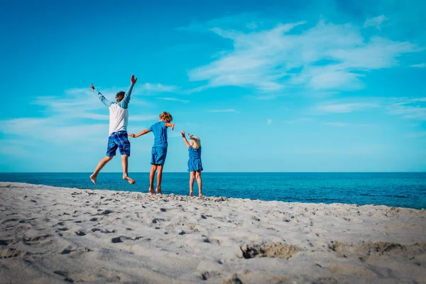 Gelukkige vader met kinderen-jongen en meisje-spelen op het strand — Stockfoto