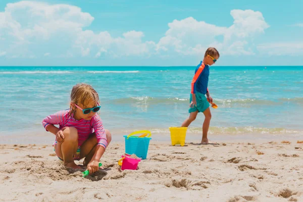 Chlapec a dívka hrát s pískem na pláži dovolená — Stock fotografie