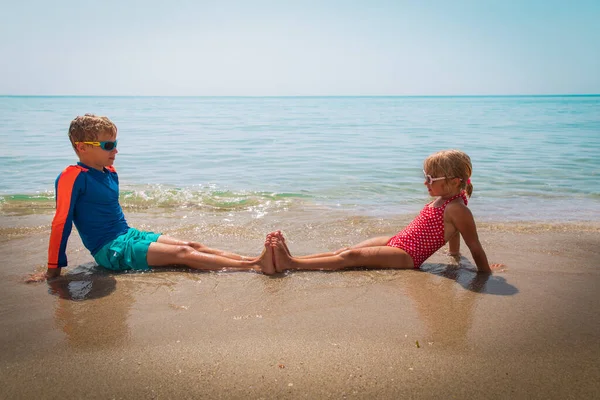 Šťastný chlapec a dívka relaxovat na tropické pláži — Stock fotografie