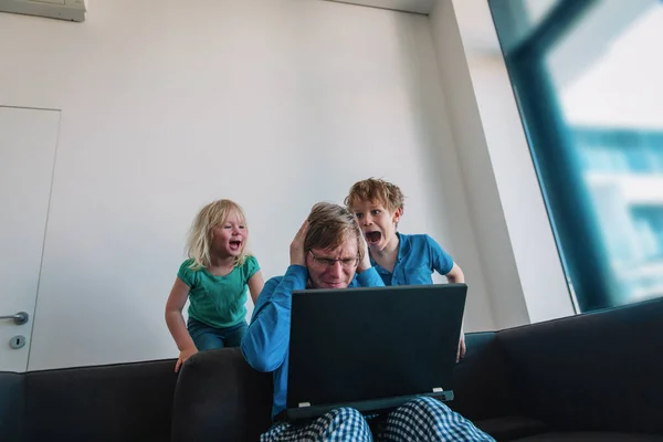 Padre tratar de trabajar desde casa mientras los niños gritan hacer ruido —  Fotos de Stock
