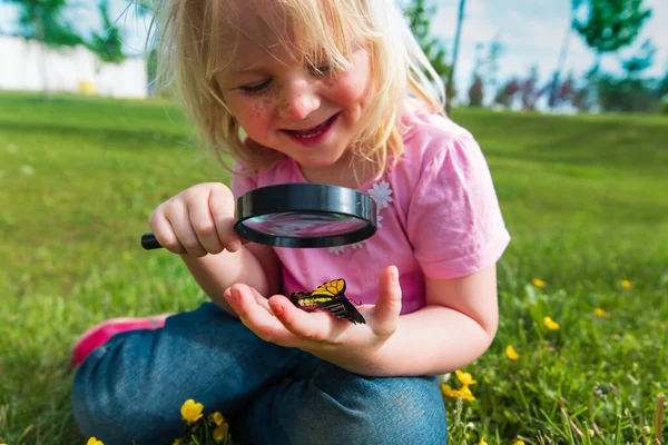 Bonito menina olhando para butterfy, crianças aprendendo natureza — Fotografia de Stock