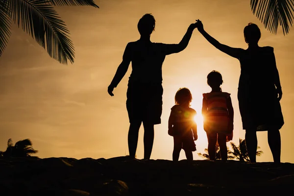 Padres que hacen hogar para los niños en la playa del atardecer, cuidado familiar —  Fotos de Stock