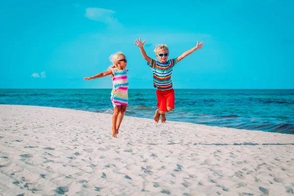 Feliz niño y niña juegan en la playa, los niños disfrutan de vacaciones tropicales — Foto de Stock