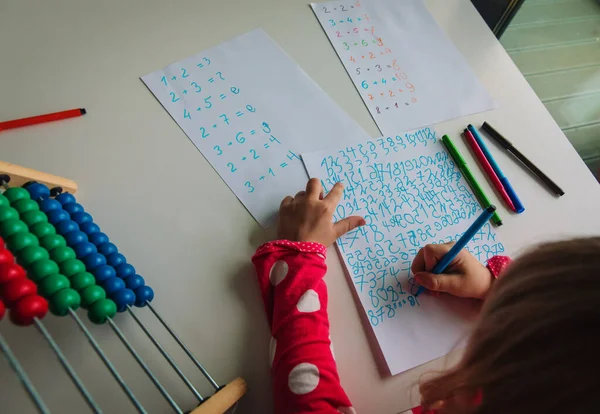 Liten flicka räkna siffror, unge gör läxor, matematik för barn — Stockfoto