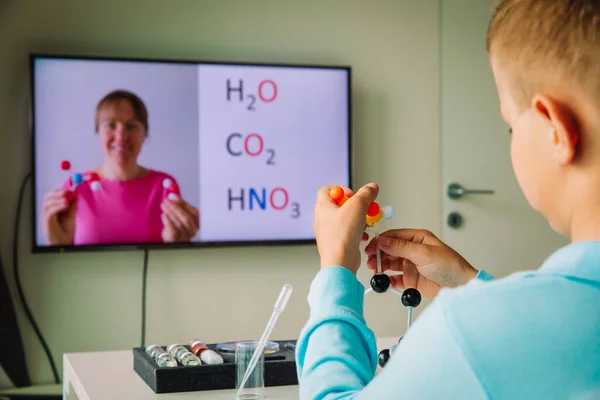 El niño aprendiendo remotamente. Chico haciendo experimentos durante la lección de química en línea en casa — Foto de Stock