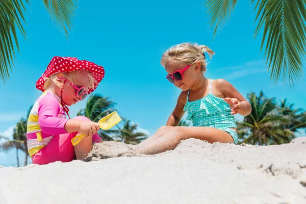 Meninas bonitos brincar com areia na praia tropical — Fotografia de Stock