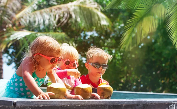 Niños felices bebiendo cóctel de coco en el resort de playa — Foto de Stock