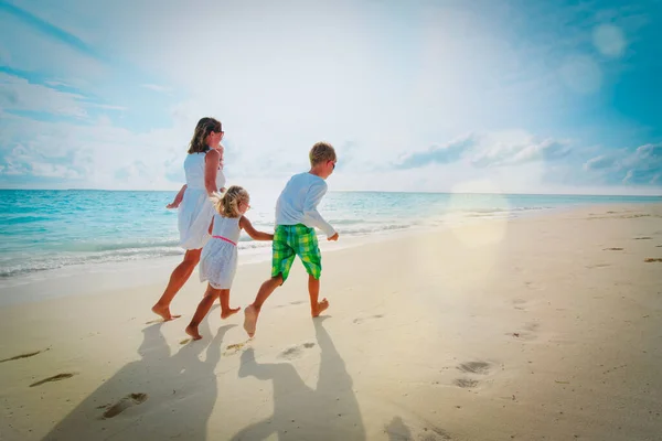 Feliz madre e hijos disfrutan de vacaciones en la playa, la familia se divierten —  Fotos de Stock