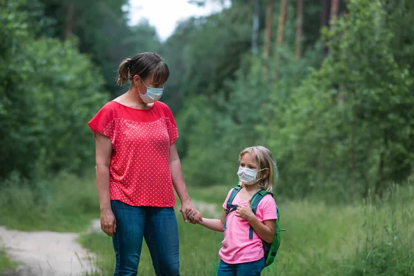 Мати і дитина з масками йдуть до школи — стокове фото