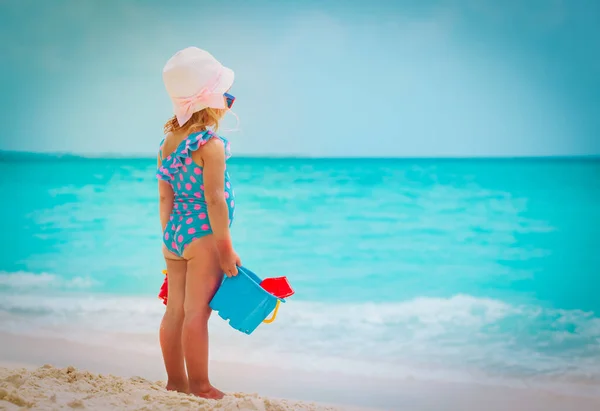 Klein meisje spelen met zand op de zomer strand — Stockfoto