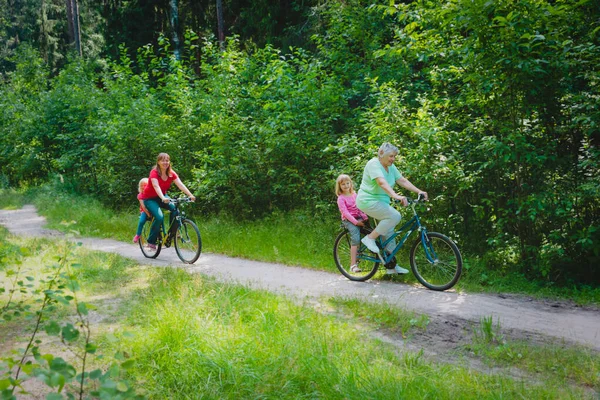 Rodzina z babcią i dzieci jazda na rowerach w przyrodzie — Zdjęcie stockowe