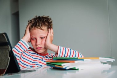 Bilgisayara bakan sıkkın ve üzgün bir genç çocuk, online iletişimden ve öğrenmekten bıkmış.