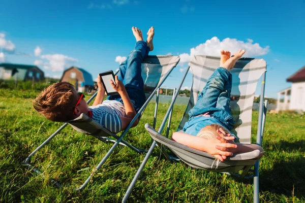 Kinder entspannen im Garten, Jungen und Mädchen verbringen den Sommer auf dem Land — Stockfoto