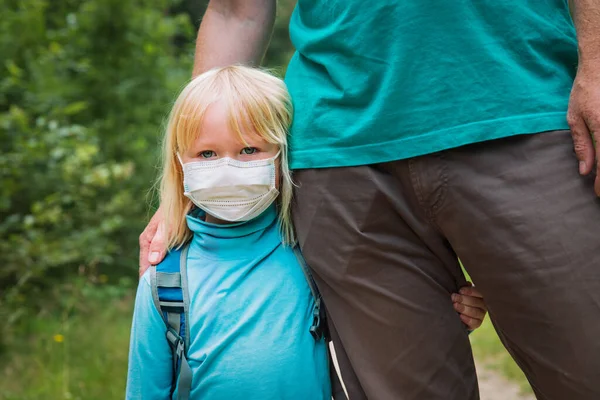 little daughter wearing mask hug father before going to school