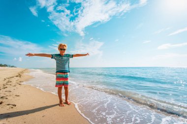 Tropik plaj tatilindeki mutlu genç çocuk.