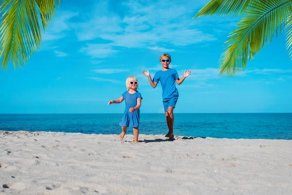 Schattig jongen en meisje dansen op het strand, kinderen genieten van vakantie aan zee — Stockfoto