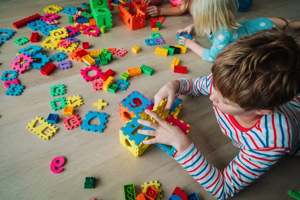 Niños jugando con rompecabezas, concepto de educación, aprendizaje a través del juego —  Fotos de Stock