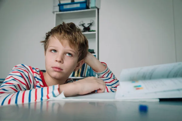 Enfant à l'air perplexe, enfant fatigué et fatigué de faire ses devoirs — Photo
