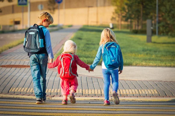 Kinder halten Händchen, während sie zur Schule gehen — Stockfoto