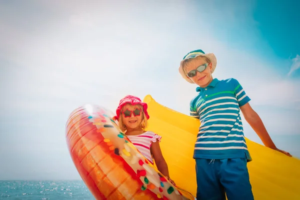 Gelukkig jongen en meisje met drijvers op strand vakantie — Stockfoto