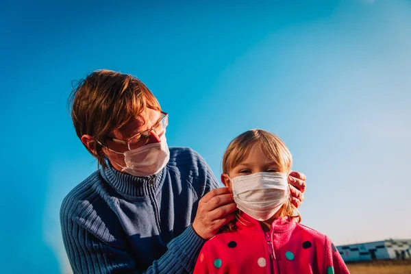 Батько наклав маску на дочку зовні, захист від коронавірусу — стокове фото